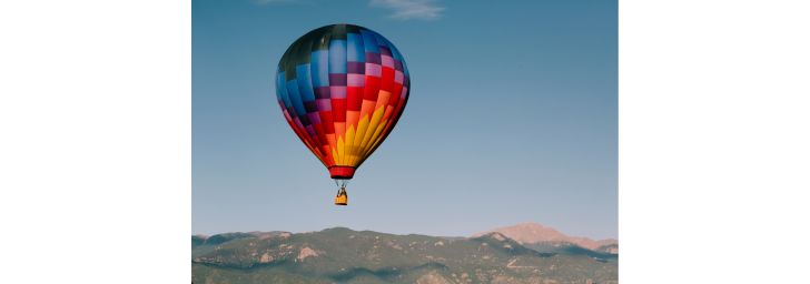 Hot Air Ballon floating above mountains