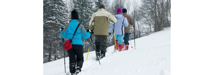 Family snowshoeing through the snow